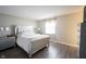 A bedroom with a queen bed, wood grain laminate flooring, and a window at 8075 N Cardinal W Cv, Indianapolis, IN 46256