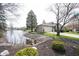Home featuring a beautiful lakeside view from the front yard, enhanced by mature trees and meticulous landscaping at 8075 N Cardinal W Cv, Indianapolis, IN 46256