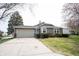 Charming one-story home with a two-car garage, a well-maintained lawn, and lush landscaping in a serene setting at 8075 N Cardinal W Cv, Indianapolis, IN 46256