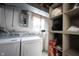 A laundry room with a washer, dryer, water heater, and shelving at 8075 N Cardinal W Cv, Indianapolis, IN 46256