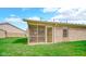 Backyard featuring screened in porch of brick home and verdant lawn at 8242 Frankdale Ct, Indianapolis, IN 46259