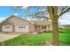 Inviting single-story home with brick facade, attached garage, and blooming tree at 8242 Frankdale Ct, Indianapolis, IN 46259