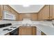 Close-up of a traditional kitchen with wooden cabinets, white appliances and vinyl flooring at 8242 Frankdale Ct, Indianapolis, IN 46259