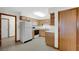 Traditional kitchen with wooden cabinets, white appliances and vinyl flooring at 8242 Frankdale Ct, Indianapolis, IN 46259