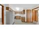 Traditional kitchen with wooden cabinets, white appliances and vinyl flooring at 8242 Frankdale Ct, Indianapolis, IN 46259