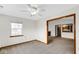 Neutral living room featuring a ceiling fan, window, and view to kitchen and fireplace at 8242 Frankdale Ct, Indianapolis, IN 46259