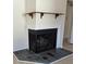 Traditional fireplace with gray slate tile and wooden mantel shelf at 8277 Sobax Dr, Indianapolis, IN 46268