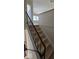 Staircase featuring natural light with laminated wood steps and black metal railing at 8277 Sobax Dr, Indianapolis, IN 46268