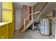 Unfinished basement space with water heater and wooden stairs at 8722 Shelby St, Indianapolis, IN 46227
