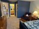 Cozy bedroom showcases blue accent wall, reading chair, dresser, and glimpses of the en-suite bathroom at 8820 Yardley Ct # 103, Indianapolis, IN 46268