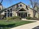 Charming clubhouse exterior with well manicured lawn, beautiful landscaping, and lovely architectural details at 8820 Yardley Ct # 103, Indianapolis, IN 46268