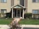 Inviting condo front entrance with well manicured landscaping and walkway, number 8820 above door at 8820 Yardley Ct # 103, Indianapolis, IN 46268