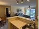 Bright kitchen with breakfast bar looking into living room with open floor plan and updated lighting at 8820 Yardley Ct # 103, Indianapolis, IN 46268