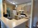 Kitchen features white appliances, neutral cabinets, and access to in unit laundry room at 8820 Yardley Ct # 103, Indianapolis, IN 46268