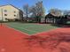 Well-maintained tennis court surrounded by a fence and lush greenery, perfect for active living at 8820 Yardley Ct # 103, Indianapolis, IN 46268