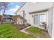 Back patio features two chairs, a table, an artificial grass rug, a privacy fence, and a tree at 9442 Avon Strand # D, Avon, IN 46123