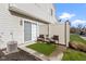 Back patio features two chairs, a table, an artificial grass rug, a privacy fence, and an AC unit at 9442 Avon Strand # D, Avon, IN 46123