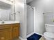 Neutral bathroom featuring a light wood vanity, a large mirror, and a glass-doored shower next to the toilet at 9442 Avon Strand # D, Avon, IN 46123