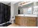 Neutral bathroom featuring a light wood vanity, a large mirror with Hollywood lighting, and a black and white shower curtain at 9442 Avon Strand # D, Avon, IN 46123