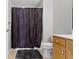 Bathroom featuring a black and white shower curtain, a toilet, and a light wood vanity with a white countertop at 9442 Avon Strand # D, Avon, IN 46123