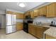 Bright kitchen with wood cabinetry, granite counters, stainless steel refrigerator, and black appliances at 9442 Avon Strand # D, Avon, IN 46123