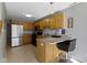 Well-lit kitchen featuring wood cabinets, granite countertops, and stainless steel refrigerator at 9442 Avon Strand # D, Avon, IN 46123