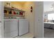 Functional laundry room with appliances, shelving, and easy access to a bedroom at 9442 Avon Strand # D, Avon, IN 46123