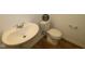 Simple bathroom with a white pedestal sink, toilet, and warning sign at 10027 Redwood Peak Ln, Indianapolis, IN 46259