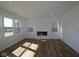 Bright living room with a modern fireplace, large windows offering ample natural light, and hardwood floors at 10027 Redwood Peak Ln, Indianapolis, IN 46259