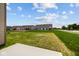 View of the backyard featuring lush lawn and neighboring homes under a bright, cloudy sky at 10543 Banyan Wood Ct, Indianapolis, IN 46239