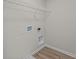 Bright laundry room with wood-look flooring and a wire shelf at 10543 Banyan Wood Ct, Indianapolis, IN 46239