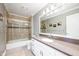 Updated bathroom features a shower-tub combo, granite countertops, and ample lighting at 12507 Doe Ln, Indianapolis, IN 46236