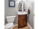 Half bathroom features a wooden vanity with a decorative mirror, and updated plumbing at 12507 Doe Ln, Indianapolis, IN 46236