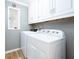Functional laundry room with a white washer and dryer, plus overhead white cabinets at 12507 Doe Ln, Indianapolis, IN 46236