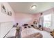 Bedroom featuring pink walls, carpeted floors, and natural light from window at 12552 Majestic Way, Fishers, IN 46037