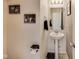 A conveniently located half-bathroom with a pedestal sink and modern fixtures, perfect for guests at 12552 Majestic Way, Fishers, IN 46037