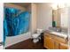 Cozy bathroom features wood floors, a marble-style vanity, and a shower with a blue shower curtain at 12926 University Cres # 2C, Carmel, IN 46032