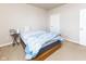 Cozy bedroom featuring a bed, small side table, neutral carpet, and a door, all bathed in natural light at 12926 University Cres # 2C, Carmel, IN 46032