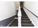 Carpeted stairwell with white walls and a black handrail for a simple and clean look at 12926 University Cres # 2C, Carmel, IN 46032