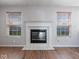 Close-up of a fireplace with a white mantel, flanked by windows with blinds, on hardwood floors at 1321 Savannah Blvd, Shelbyville, IN 46176