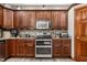 Spacious kitchen showcases stainless steel appliances, abundant wooden cabinetry and modern gray flooring at 1513 Tottenham Dr, Danville, IN 46122
