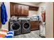 Laundry room with dark wood cabinets, folding counter, and front-loading washer and dryer at 1513 Tottenham Dr, Danville, IN 46122