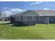Spacious backyard featuring a well-maintained lawn and the rear view of a brick single-story home at 1623 Senior Ct, Shelbyville, IN 46176
