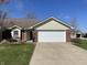 Charming single-story home showcasing a two-car garage, brick accents, and a well-manicured lawn at 1623 Senior Ct, Shelbyville, IN 46176