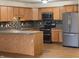 Well-equipped kitchen with stainless steel appliances, oak cabinets, and a stylish mosaic backsplash at 1623 Senior Ct, Shelbyville, IN 46176
