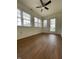 Bright sunroom featuring three large windows, a ceiling fan, and wood flooring at 1623 Senior Ct, Shelbyville, IN 46176