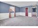 Spacious bedroom with neutral carpet, blue paneled walls, and ample natural light from the window at 1816 N Moreland Ave, Indianapolis, IN 46222