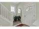 Bright foyer with white door, staircase and hardwood floors creates an inviting entrance at 2018 Cornell Ave, Indianapolis, IN 46202