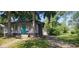 Delightful home with mature trees, a turquoise door, and a long driveway leading to a detached garage at 213 S Brittain Ave, Muncie, IN 47303