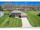 Aerial view of a home with lush lawn, a driveway leading to the garage and mature trees at 2328 Discovery Dr, Anderson, IN 46017